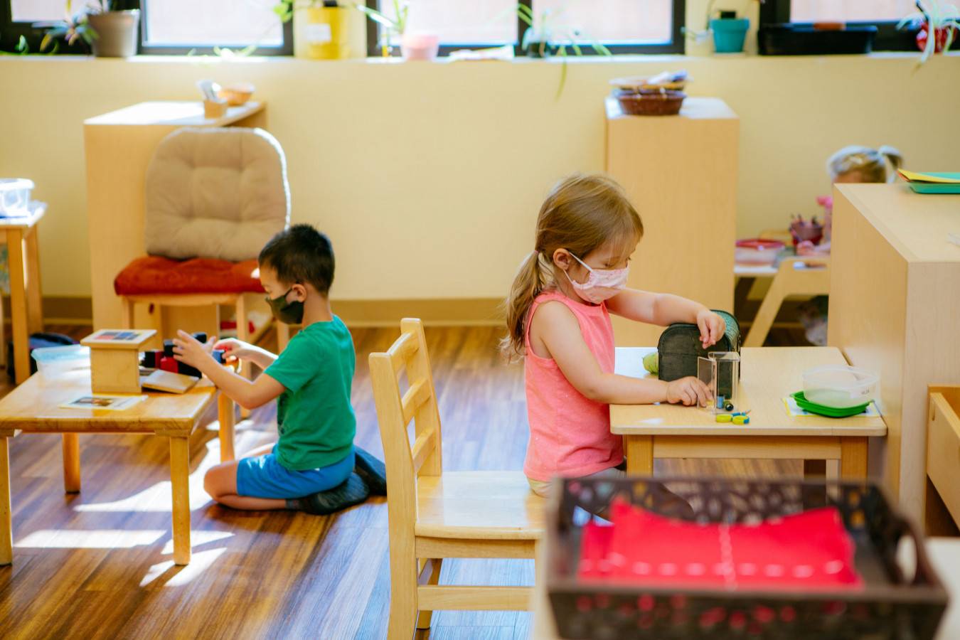 Children wearing masks in the classroom while working independently